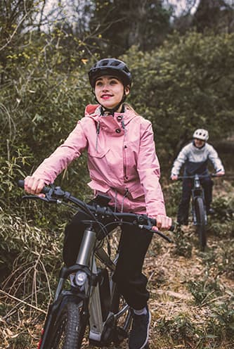 Young woman riding an electric bike on a trail.